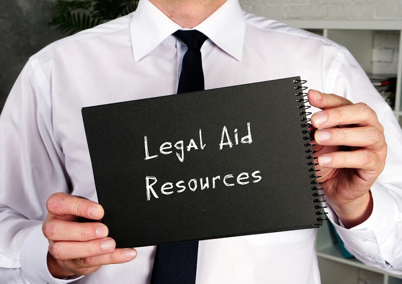 man holding a binder with the words legal aid resources printed on the outside.